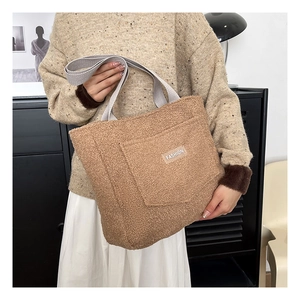 Dettaglio della borsa tote in peluche kaki con manici in tessuto e etichetta Fashion