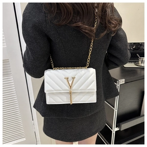 Vue détaillée du sac à bandoulière blanc matelassé avec logo V doré et pampille à franges