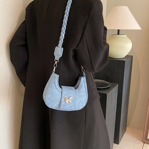Light blue crescent shoulder bag with golden butterfly buckle and woven strap