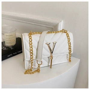 Détail du sac à main en cuir PU blanc matelassé avec logo V doré et bandoulière chaîne