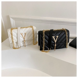 Détail de sacs en cuir matelassé avec boucle en V dorée et bandoulière en chaîne