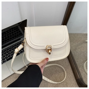 Gros plan d'un sac vintage crème avec fermoir doré et détails de coutures décoratives