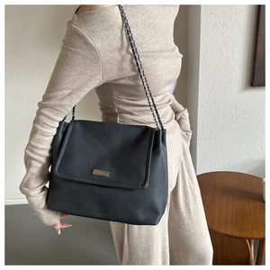 Vue détaillée du sac cabas en cuir noir avec bandoulière en chaîne et boucle élégante