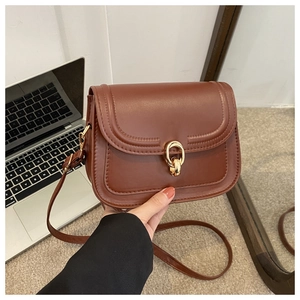 Détail du sac à bandoulière en cuir PU marron avec boucle dorée et fine bandoulière