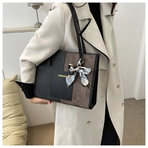 Detail of color-block tote bag with FASHION print and polka dot scarf on handle