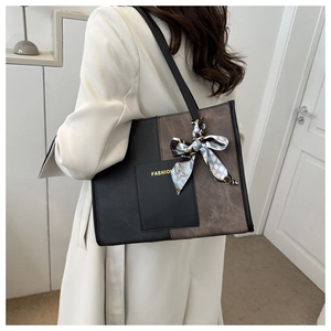 Detailed shot of large patchwork tote bag with fashion text and polka dot scarf accessory