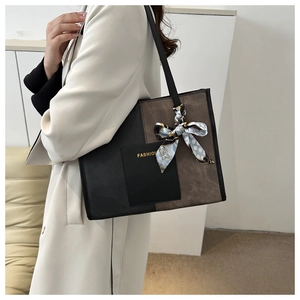 Detail of color-block tote bag with FASHION gold text and decorative blue polka dot scarf