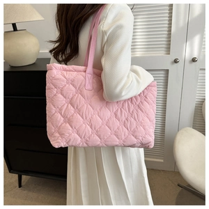 Detail of pink quilted tote bag with soft nylon texture and elegant shoulder strap