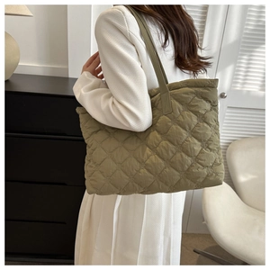 Detail of green quilted oversized tote bag showing diamond stitch and puffy texture