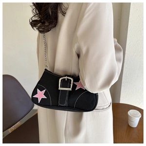 Close-up of black canvas underarm bag with pink stars and a large silver buckle detail