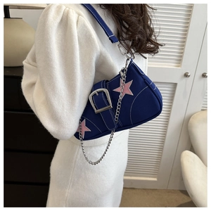 Detail of blue canvas crescent bag with pink star patch and silver metal chain accessory