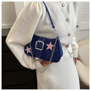 Detail of navy canvas crossbody bag with pink star patches and silver metal buckle