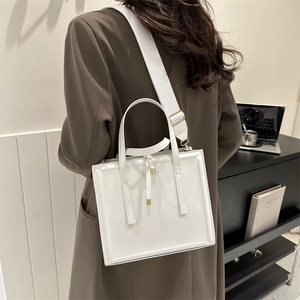 Minimalist white square crossbody bag with adjustable wide strap and gold hardware accents
