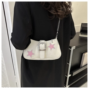 Detail of white canvas underarm bag with pink star patches and shiny silver buckle