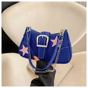 Detail of blue canvas shoulder bag with pink star patch and large silver buckle closure