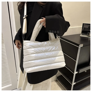 Détail du sac cabas matelassé blanc avec poignées épaisses et bandoulière en tissu