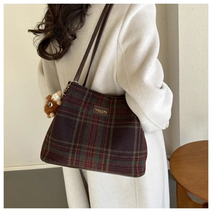 Detalle de bolso de lana con cuadros vintage y colgante de peluche de erizo marrón