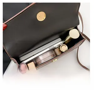 Detail shot of small crossbody bag interior capacity with brown crocodile texture leather