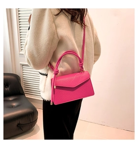 Detail of rose pink snake skin embossed handbag with elegant top handle and flap cover