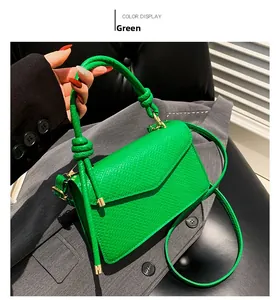Detail of green snake-embossed shoulder bag with gold hardware and knot handle detail
