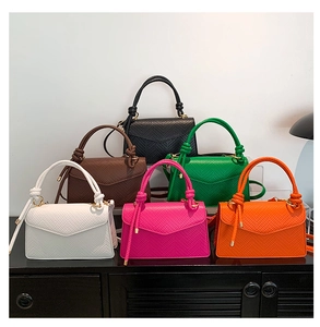 Collection of colorful mini crossbody bags with knotted handles and crocodile texture