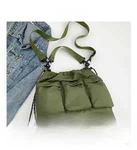 Macro detail of forest green quilted nylon crossbody bag with functional multi-pocket design