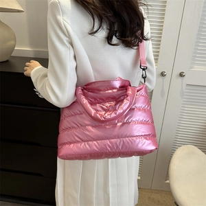 Sac fourre-tout matelassé rose métallique avec bandoulière porté à l'épaule de côté