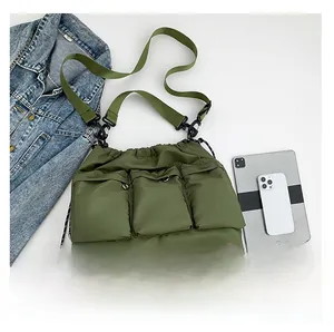 Flat lay of olive green quilted nylon tote bag with three front pockets and accessories