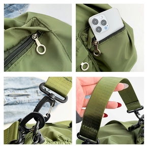 Detail view of military green nylon crossbody bag with metal zippers and wide strap