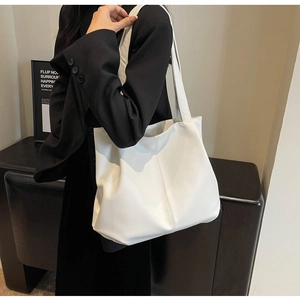 Detail of ivory white faux leather tote bag showing lychee grain texture and stitching