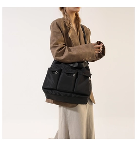 Detail of a black multi-pocket nylon crossbody bag in a trendy workwear casual style