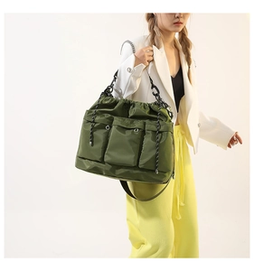 Detail of army green nylon puffer tote bag with multiple pockets and silver chain strap