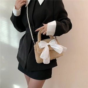 Plush crossbody bag for women with large white satin bow and long pearl chain strap