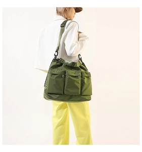 Olive green nylon crossbody bag with dual front pockets and metal chain detail