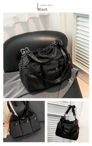 Detail view of black nylon messenger bag with drawstring closure and three front pockets