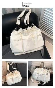 White nylon shoulder bag detail featuring three front flap pockets and adjustable wide strap