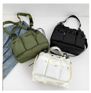 Detailed top view of nylon crossbody bags in green black and white with three pockets