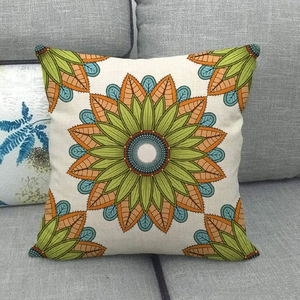 Linen square throw pillow with floral mandala pattern on a gray fabric sofa