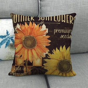 Détail de taie d'oreiller en lin à motif tournesol vintage sur canapé gris