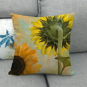Texture détaillée de la housse de coussin en lin à motif tournesol sur canapé gris