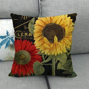 Détail d'imprimé tournesol rétro sur housse de coussin en lin posée sur un canapé gris
