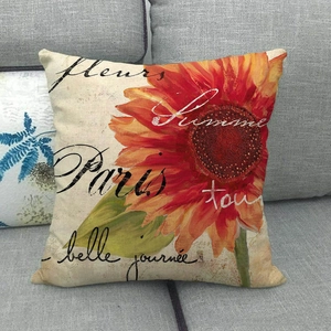 Détail macro de la housse de coussin en lin imprimé tournesol sur un canapé gris
