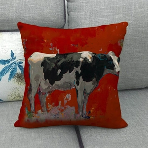 Detail of red linen pillowcase with artistic oil painting cow pattern on grey sofa