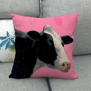 Close-up of linen cushion cover featuring oil painting style cow print on pink background