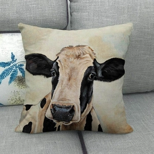 Detailed view of the linen throw pillow case featuring a realistic cow portrait on a sofa