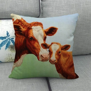 Close-up of linen cushion cover with oil painting cow pattern on grey sofa