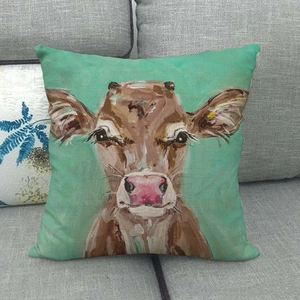 Close-up of linen pillow cover featuring a painted brown cow on mint green background
