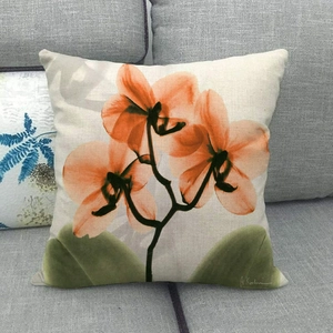 Linen square pillowcase with orange floral watercolor ink pattern on a gray sofa