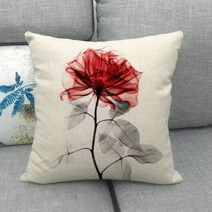 Detail of red and black ink floral print on a beige linen square decorative pillowcase