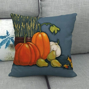 Detail of square linen pillow cover with pumpkins and pears on a grey fabric sofa